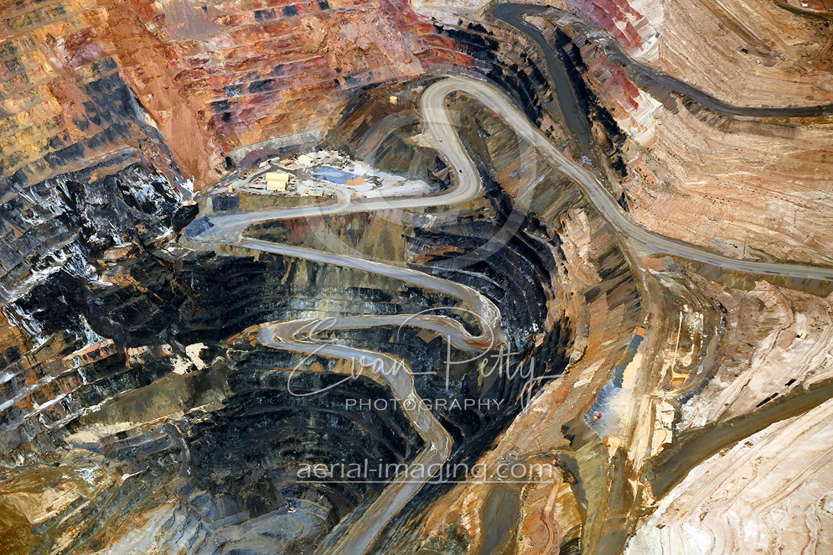 aerial view of road going down open pit mine