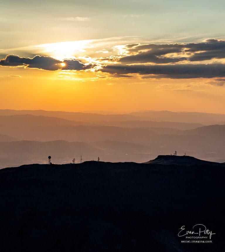 Radio towers on top of the mountains near sunset