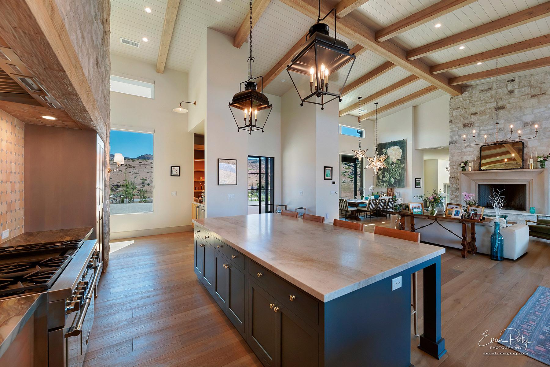 Kitchen area with high ceilings and living room behind.