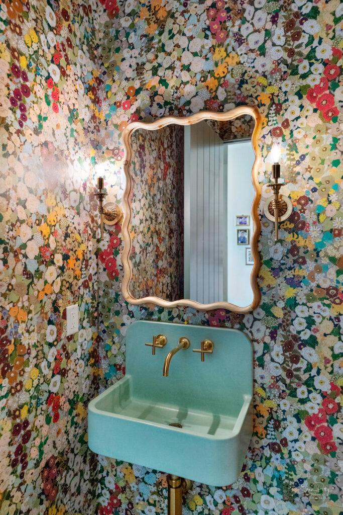 Bathroom vanity with wallpaper walls.
