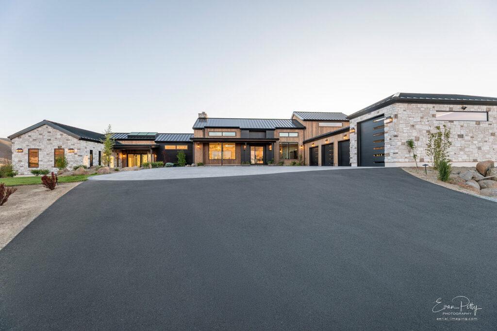 Exterior view at dusk of the driveway and the front of the house.