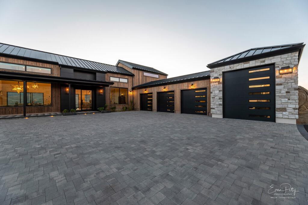 Dusk in the front of the house with driveway and garage views.