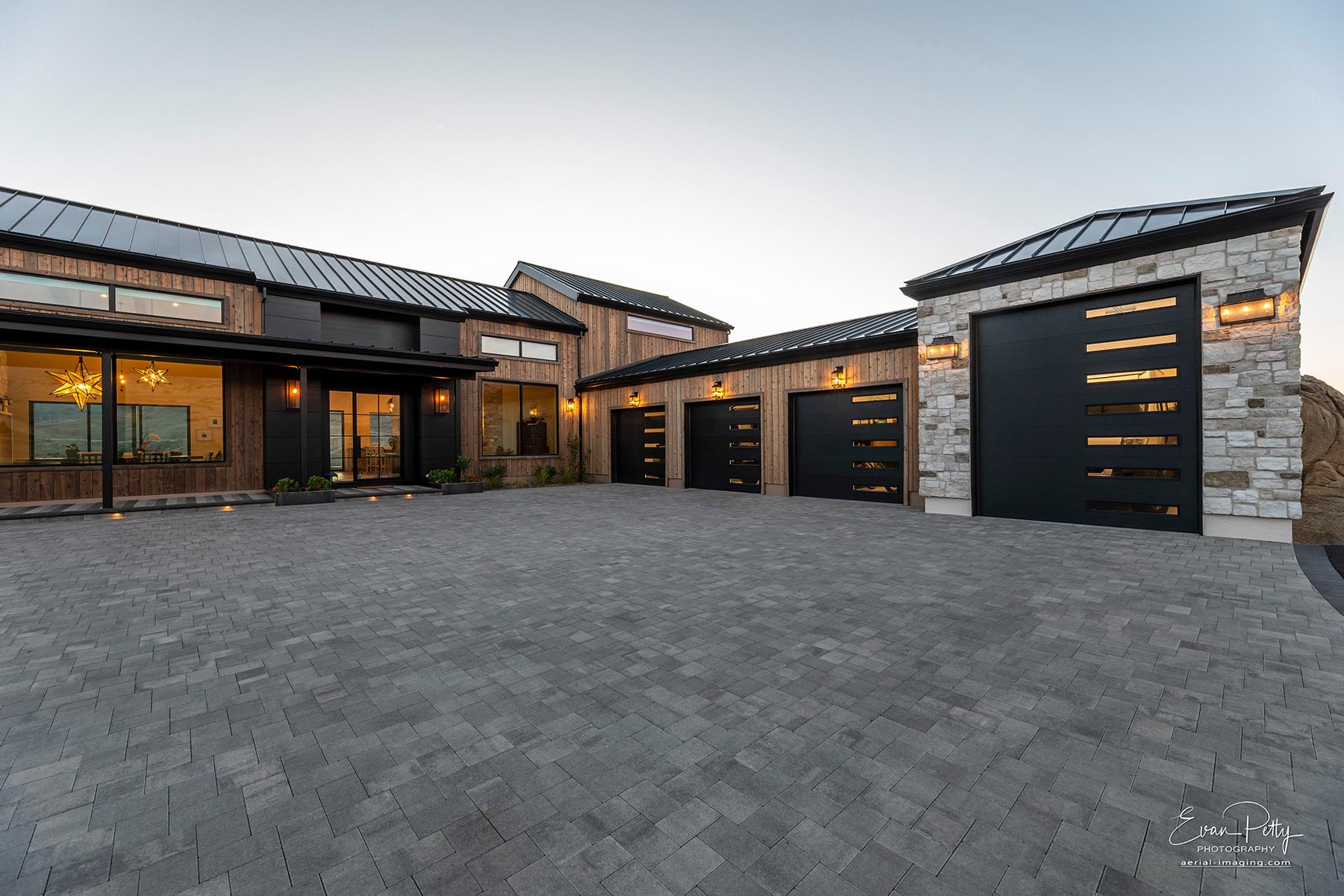 Dusk in the front of the house with driveway and garage views.