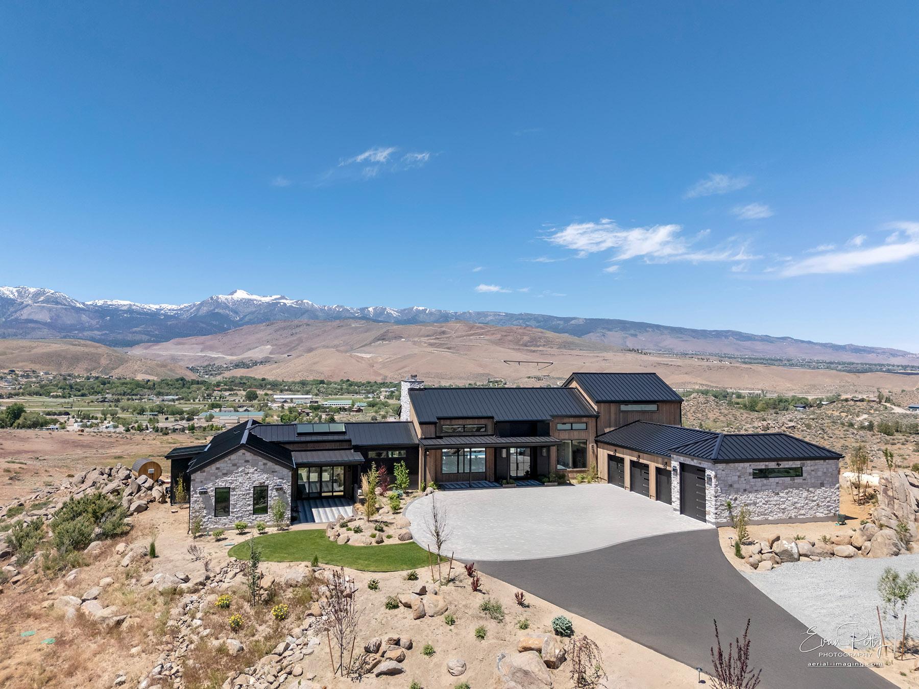 Drone view with mountains behind the house.